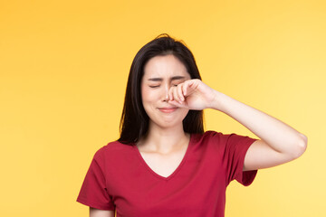 Beautiful face of sad woman serious and crying facial expression feeling depressed isolated on yellow background