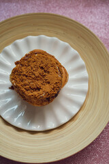 Cinnamon rolls with Lotus BIscoff crumbs topping on a white and bamboo plate.