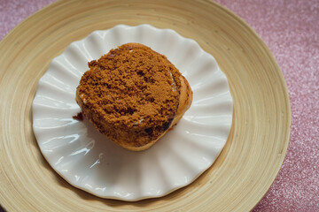 Cinnamon rolls with Lotus BIscoff crumbs topping on a white and bamboo plate.