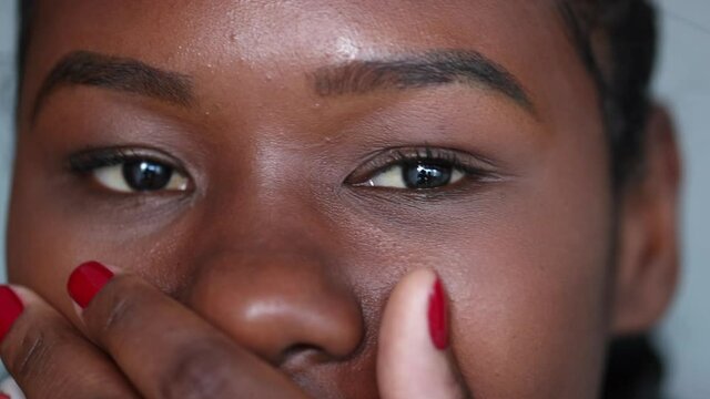 Black girl covering mout with hand close-up eyes