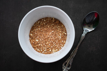 breakfast of healthy banana flakes with chocolate, oat, granola in a white bowl.