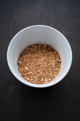 breakfast of healthy banana flakes with chocolate, oat, granola in a white bowl.