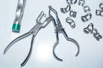 Orthodontic instruments. Dental pliers for installing the mountings. Dentist tools set. Dental technician tools top view. Tongs dental punch. Instruments for odontic treatment. Denture insertion tool