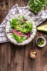 Salad from radish, avocado, microgreen, cabbage, cucumber and lettuce leaves. Vegan food. Dietary menu. vertical image, place for text, Top view. Flat lay