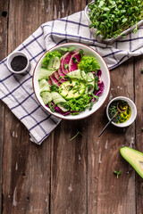Vegan, detox salad with lamb's lettuce, avocado, cucumber, watermelon radish, seeds, Dietary menu. vertical image, place for text, Top view. Flat lay