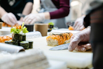 Obraz na płótnie Canvas people making sushi on kitchen