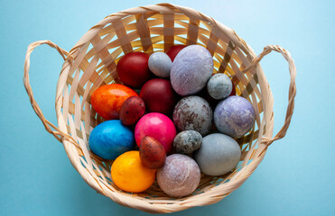 On a blue background, a basket with colorful Easter eggs.The Concept Of Easter