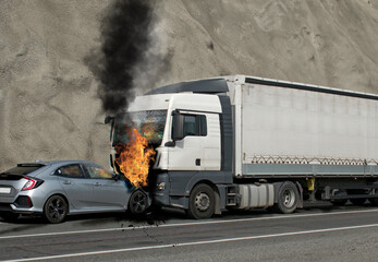 Collision between a car and a truck transporting goods. Accident followed by fire. The car caught...