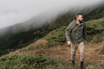 Young male traveler climbs the trail uphill. Tourism concept.