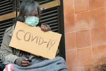 A homeless man carries a cvid-19 sign, a problem of modern megacities.