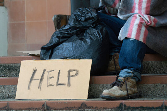 Help Sign From A Homeless Man Sitting On The Side Of The Road.