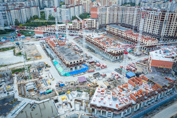 Fototapeta na wymiar Top view of the construction site. Construction of new high-rise buildings. housing construction. A new city quarter is being built. Sale of apartments in new houses. Urban infrastructure.