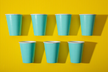 Eco disposable paper cups on yellow background
