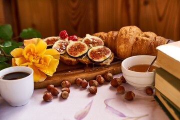 Coffee and croissant for Breakfast. French toast with figs near a yellow rose. High quality photo