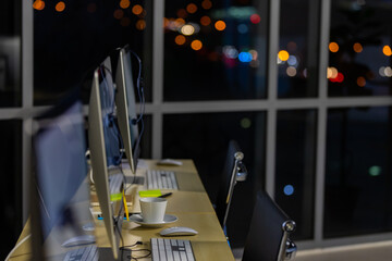 Business office desk with computer and city light bokeh background.