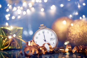 New Year's at midnight - Old clock with Christmas decoration, champagne and holiday lights