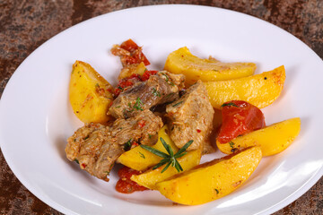 Baked pork meat with potao and tomato