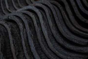 The texture of long layered waves, concrete slate roofing, solid tiles, aged, battered and cracked. Abstract gray retro background.