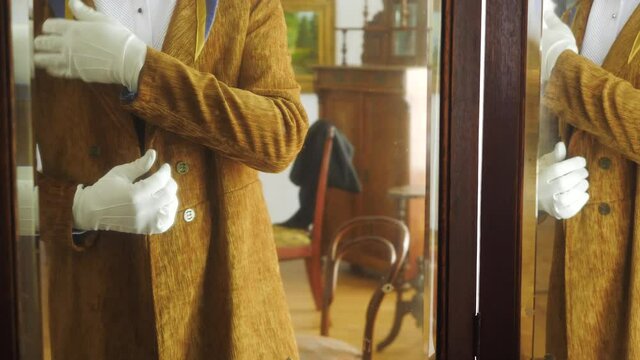 Aristocrat puts on jacket. Stock footage. Rich man dresses for celebration in 19th century. Vintage outfit on aristocratic man of 19th century. Historical outfit of last century