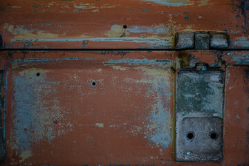 Wooden surface of the box, rusty metal parts, painted with paint and peeled off from old age, holes, nails in the base, an opening door. Screensaver background