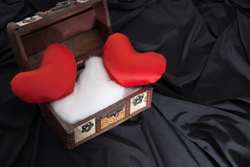 Box with red hearts on tight fabric.