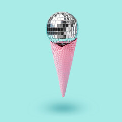 Disco ball ice cream in pink waffle cone levitates on blue background. Minimal holiday party concept