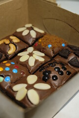 Chocolate fudgy brownies with various toppings.