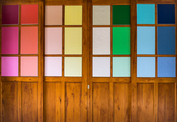 Wooden doors with colorful glass. Toned image.