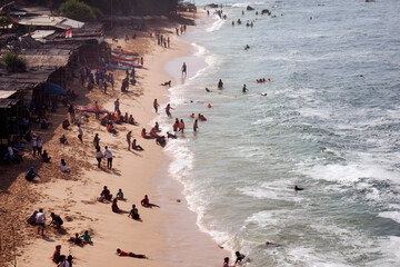 Views of beaches in the morning on holiday seasons with people and tourists swimming and sunbathing captured high angle.