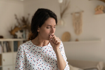 Fototapeta na wymiar Sick young Caucasian woman cough suffer from flu or cold at home. Unhealthy millennial female have covid-19 coronavirus symptoms, feel unwell ill. Girl struggle with influenza or bronchitis.