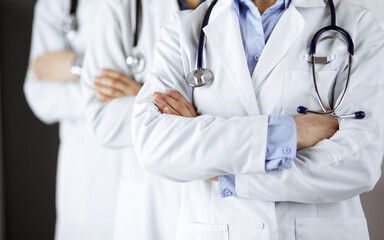 Group of modern doctors standing as a team with arms crossed in hospital office and ready to help patients. Medical help, insurance in health care, best disease treatment and medicine concept