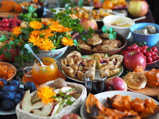 Fragment of a set table with orange marigold flowers. Thanksgiving Day. Healthy rustic natural food.