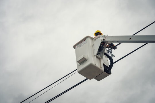 Lineman use aerial lifts to install cable spacer and maintenance the Electric Power Transmission and Distribution.