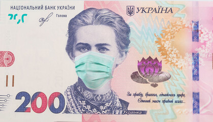 200 hryvnia banknote with Lesya Ukrainka in a medical mask, horizontal. Economic crisis has affected Ukraine. Ukrainian money, coronavirus concept, montage, close up.