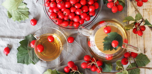A cup of herbal tea with hawthorn on a white plate with berries. View from above.The hawthorn harvesting season for future use. Alternative medicine.
