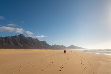 Fototapeta na wymiar Children walking on Cofete beach, Fuerteventura island