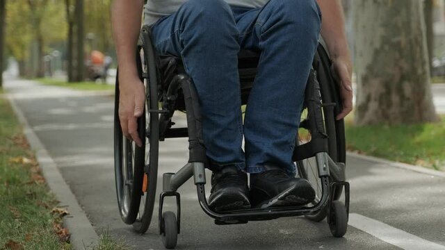 Handicapped man in wheelchair walk at the park alley