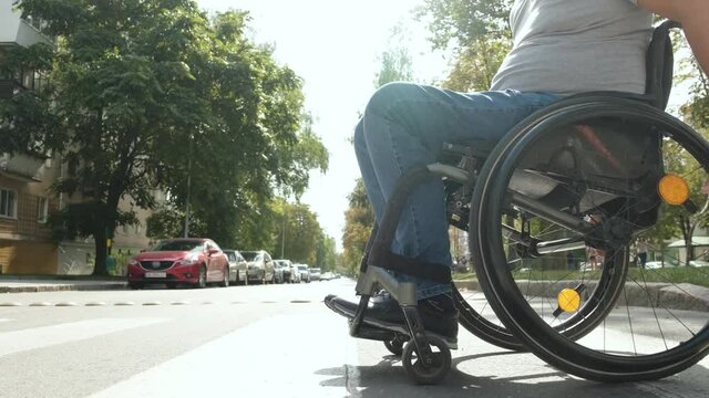 Handicapped man in wheelchair crossing street road