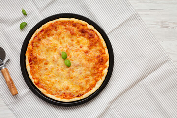 Homemade Neopolitan Pizza with Cheese and Basil, top view. Flat lay, from above, overhead. Copy space.