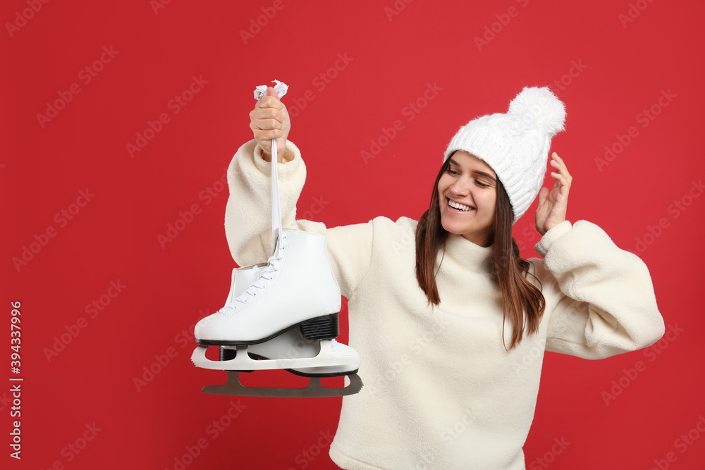 Poster Happy woman with ice skates on red background