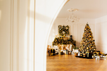 bright Christmas room with Christmas tree and fireplace in black and gold colors, selective focus and space for text