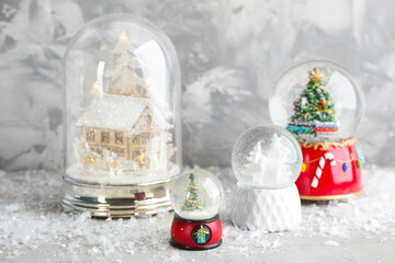 Set of different beautiful snow globes on table