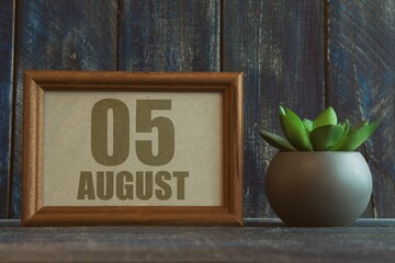 august 5th. Day 5 of month, date in frame next to succulent on wooden background summer month, day of the year concept