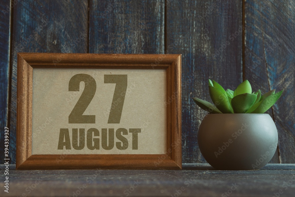 Wall mural august 27th. Day 27 of month, date in frame next to succulent on wooden background summer month, day of the year concept