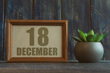 december 18th. Day 18 of month, date in frame next to succulent on wooden background winter month, day of the year concept