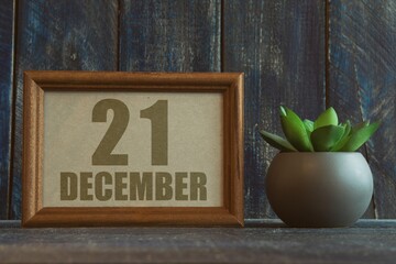 december 21st. Day 20 of month, date in frame next to succulent on wooden background winter month, day of the year concept
