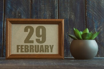 february 29th. Day 29 of month, date in frame next to succulent on wooden background winter month, day of the year concept