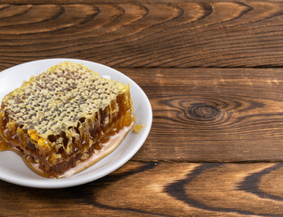 honey and honeycomb in a plate on a wooden background