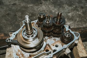 The mechanic is assembling the crankshaft and motorcycle gear.