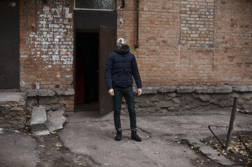 Obraz na płótnie Canvas Guy goes for a walk in a gas mask during quarantine, isolation covid 19, november